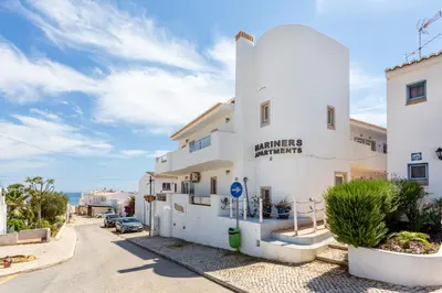a white building with the ocean in the background at Mariners (5) - Bright and stylish apartment - walk to the beach in Luz