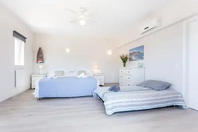 a white bedroom with two beds and a dresser at Mariners (5) - Bright and stylish apartment - walk to the beach in Luz