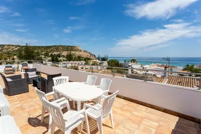 a balcony with a table and chairs and the ocean at Mariners (1) - Bright and stylish apartment - walk to the beach in Luz