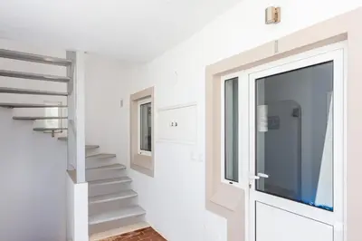 a hallway with stairs and a sliding glass door at Mariners (1) - Bright and stylish apartment - walk to the beach in Luz