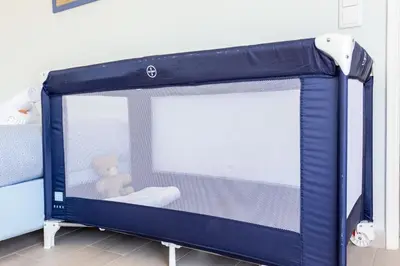 a blue crib with a teddy bear in it at Mariners (1) - Bright and stylish apartment - walk to the beach in Luz