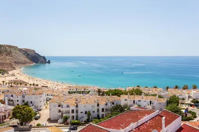 a view of a beach with white buildings and the ocean at Mariners (1) - Bright and stylish apartment - walk to the beach in Luz