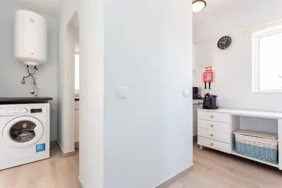 a white laundry room with a washer and dryer at Mariners (1) - Bright and stylish apartment - walk to the beach in Luz