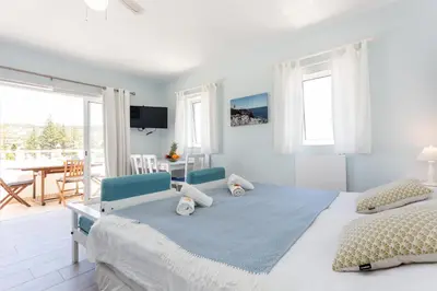 a white bedroom with a large bed and a dining room at Mariners (1) - Bright and stylish apartment - walk to the beach in Luz
