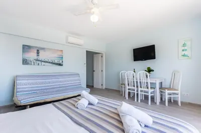 a bedroom with a bed and a table and chairs at Mariners (2) - Bright and stylish apartment - walk to the beach in Luz