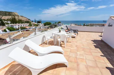 a balcony with white chairs and a view of the ocean at Mariners (2) - Bright and stylish apartment - walk to the beach in Luz