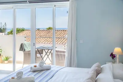 a bedroom with a bed and a view of the ocean at Mariners (2) - Bright and stylish apartment - walk to the beach in Luz