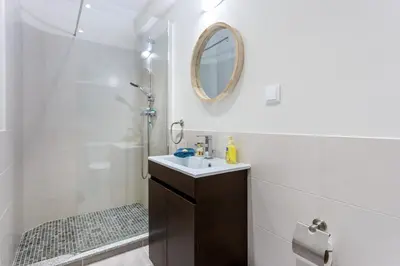 a bathroom with a sink and a shower with a mirror at Mariners (2) - Bright and stylish apartment - walk to the beach in Luz