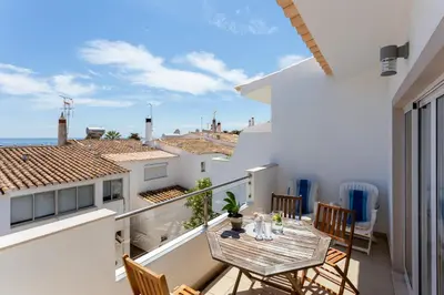 a balcony with a table and chairs and a view of the ocean at Mariners (3) - Bright and stylish apartment - 2 minute walk to the beach in Luz