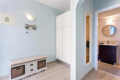 a living room with white cabinets and a mirror at Mariners (3) - Bright and stylish apartment - 2 minute walk to the beach in Luz