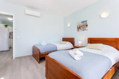 a bedroom with two beds and a refrigerator at Mariners (4) - Bright and stylish apartment in Luz
