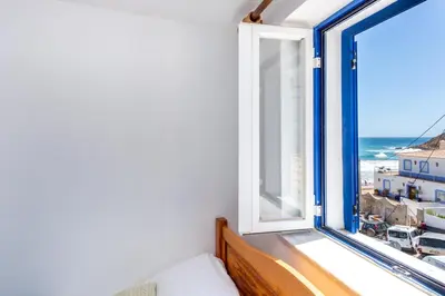 a room with a window with a view of the ocean at Casa Pedro Burgau in Burgau