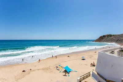 a group of people on a beach near the ocean at Casa Pedro Burgau in Burgau