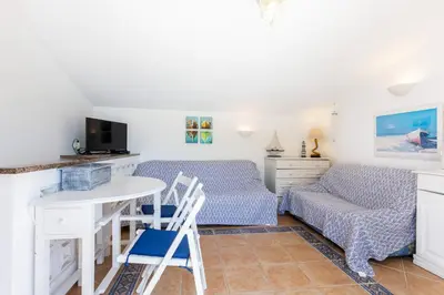 a room with two beds and a table and chairs at Casa Pedro Burgau in Burgau
