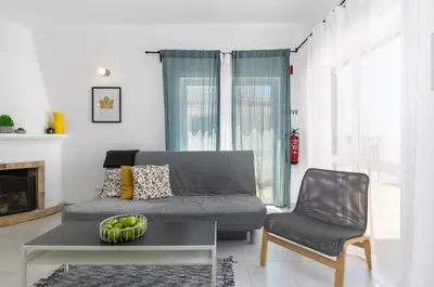 a living room with a couch and a chair at Cozy and sunny villa just some steps from the sea in Luz