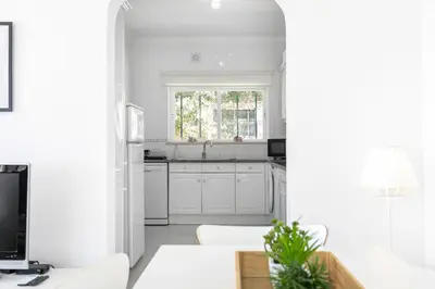 a kitchen with white cabinets and a window at Cozy and sunny villa just some steps from the sea in Luz