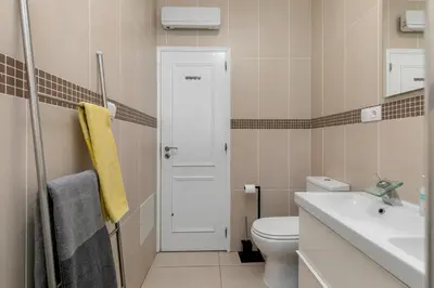 a bathroom with a white toilet and a sink at Cozy and sunny villa just some steps from the sea in Luz