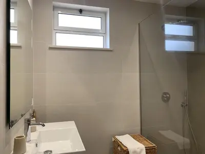 a white bathroom with a sink and a shower at Monte Lemos 29 in Luz