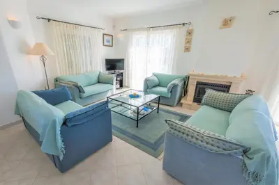 a living room with blue couches and a fireplace at Monte Lemos 29 in Luz