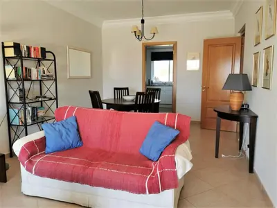 a living room with a red couch with blue pillows at Boavista 73 in Lagos