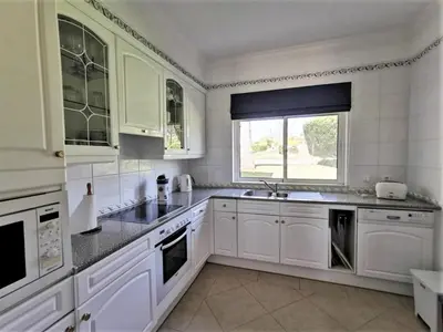 a white kitchen with white cabinets and a window at Boavista 73 in Lagos