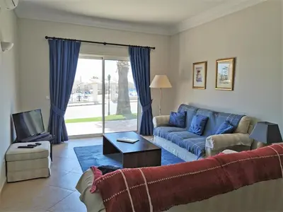 a living room with a blue couch and a tv at Boavista 73 in Lagos