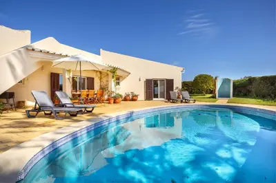 a swimming pool in front of a house at Villa Oceanis in Luz