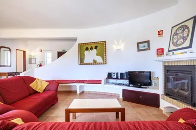 a living room with a red couch and a fireplace at Villa Oceanis in Luz