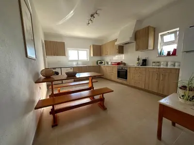 a large kitchen with wooden tables and benches in it at Villa Oceanis in Luz