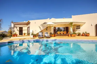 a swimming pool in front of a house at Villa Oceanis in Luz