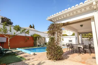 a house with a swimming pool and a table and chairs at Villa Goshen in Lagos
