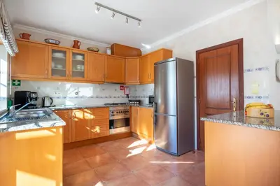 a kitchen with wooden cabinets and a stainless steel refrigerator at Villa Goshen in Lagos