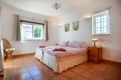 a bedroom with a bed and two windows at Villa Goshen in Lagos