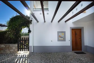 a white building with a wooden door and a fence at Villa Goshen in Lagos