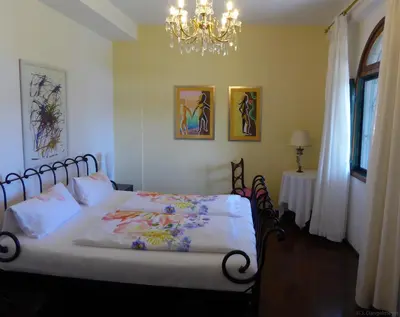 a bedroom with a bed and a chandelier at Villa Erika Madeira in Caniço