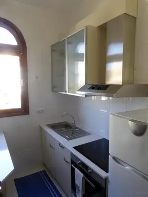 a white kitchen with a sink and a stove at Villa Erika Madeira in Caniço