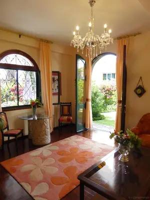 a living room with a chandelier and a room with a table at Villa Erika Madeira in Caniço