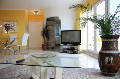 a living room with a tv and a glass table at Villa Erika Madeira -Penthaus- in Caniço