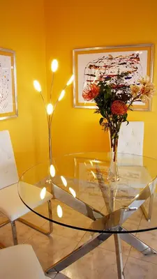a glass table with a vase of flowers and lights at Villa Erika Madeira -Penthaus- in Caniço
