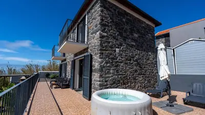a patio with a hot tub next to a building at Casa da Felicidade by LovelyStay in Prazeres