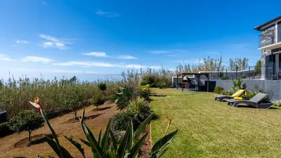 a garden with chairs and plants and a building at Casa da Felicidade by LovelyStay in Prazeres