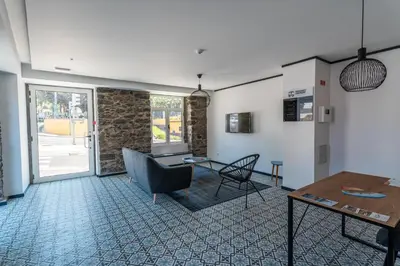 a living room with a table and a chair at Zarco Apartments by Mercado Funchal in Funchal