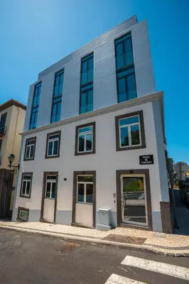 a tall white building with windows on a street at Zarco Apartments by Mercado Funchal in Funchal