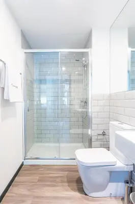 a bathroom with a shower and a toilet and a sink at Zarco Apartments by Mercado Funchal in Funchal