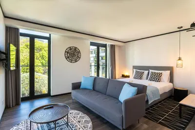 a bedroom with a bed and a couch and a table at Zarco Apartments by Mercado Funchal in Funchal