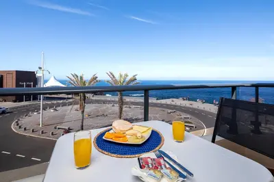 a table with a plate of food and orange juice at Perola Views Inn by Homie in Porto Moniz