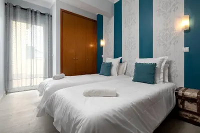 two beds in a room with blue and white at Perola Views Inn by Homie in Porto Moniz