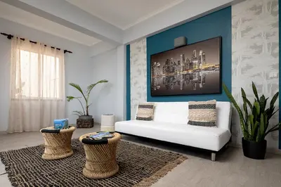 a living room with a white couch and a blue wall at Perola Views Inn by Homie in Porto Moniz