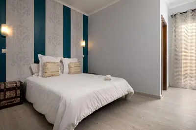a bedroom with a bed with white sheets and pillows at Perola Views Inn by Homie in Porto Moniz