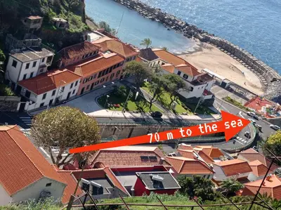 an aerial view of a beach with houses and a plane at The Rum Inn in Calheta